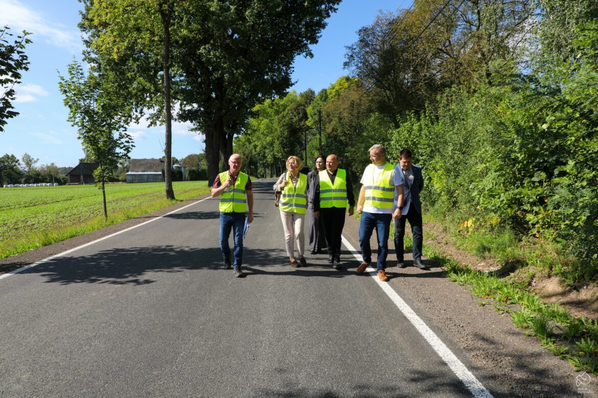 Wyremontowana nawierzchnia ul. Zawadzkiego w Rudołtwociach. Drogą idą przedstawiciele samorządów i wykonawcy